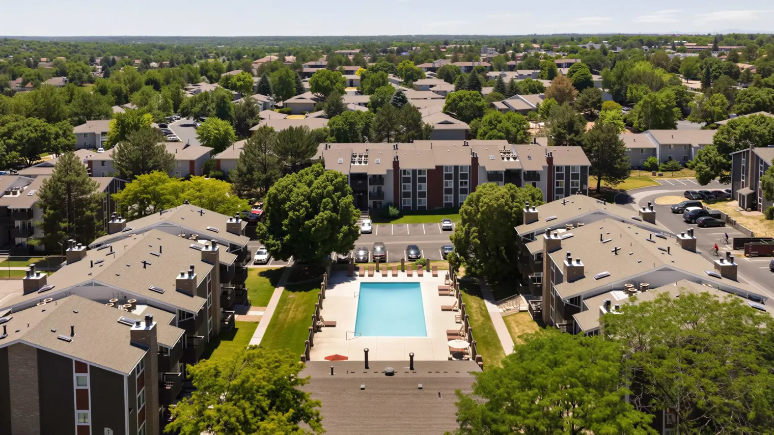 Aerial view of Oak Ridge Apartments with heated pool, courtyards and tree-lined community in Aurora, CO