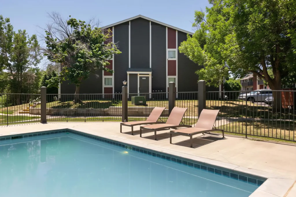 Heated swimming pool with lounge chairs at Oak Ridge Apartments in Aurora, Colorado