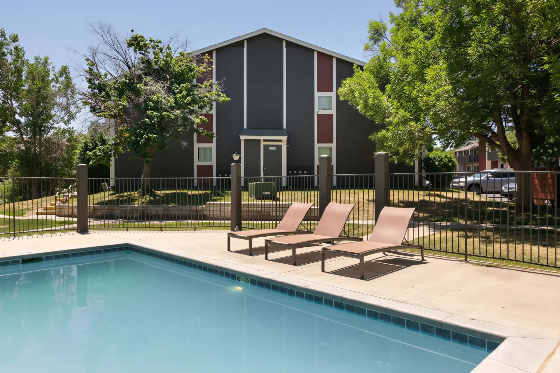 Heated swimming pool with lounge chairs at Oak Ridge Apartments in Aurora, Colorado