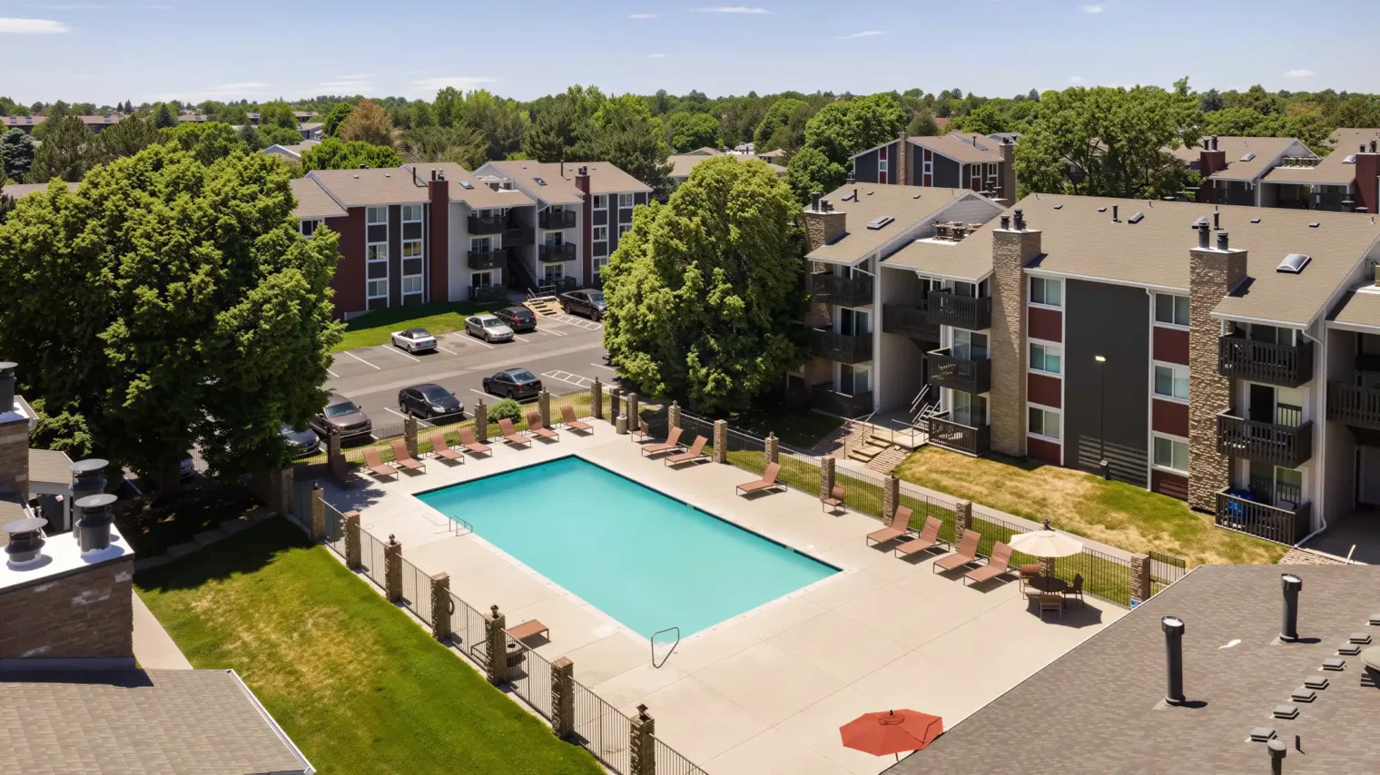 Aerial view of heated swimming pool and apartment buildings at Oak Ridge Apartments in Aurora, CO