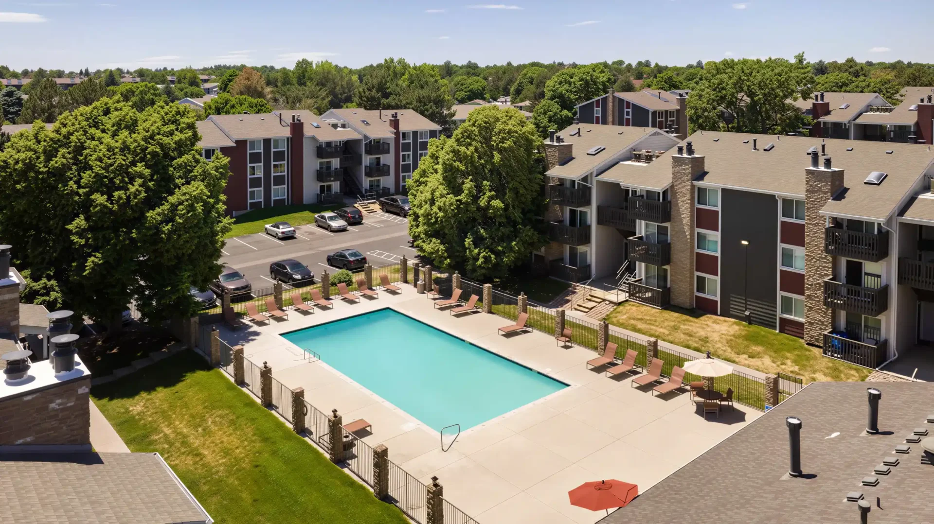 Aerial view of heated swimming pool and apartment buildings at Oak Ridge Apartments in Aurora, CO
